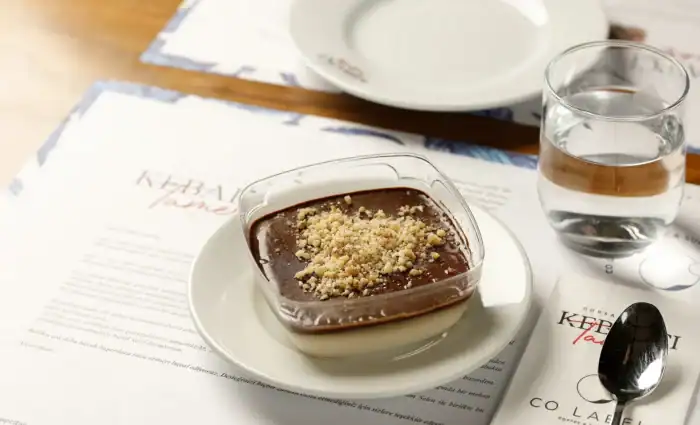 Kebapçı Tamer'in imza lezzeti olan, üzerinde dondurma ve fıstık ile servis edilen, şerbetli ve cevizli Ada Tatlısı.