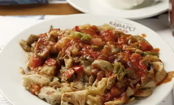 Kebapçı Tamer'in et yemeyen misafirleri için hazırladığı özel Vejetaryen Bursa Kebabı; közlenmiş mantar, patlıcan, domates ve biber ile servis ediliyor.